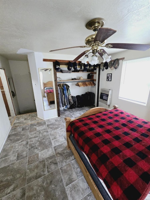 tiled bedroom with a closet, ceiling fan, and a textured ceiling