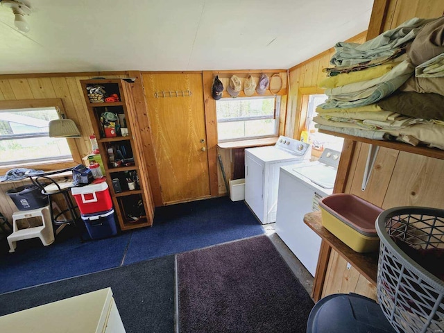 washroom with washer and dryer and wooden walls