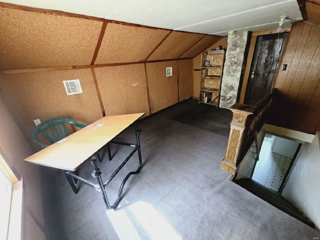 interior space featuring wood walls and carpet flooring