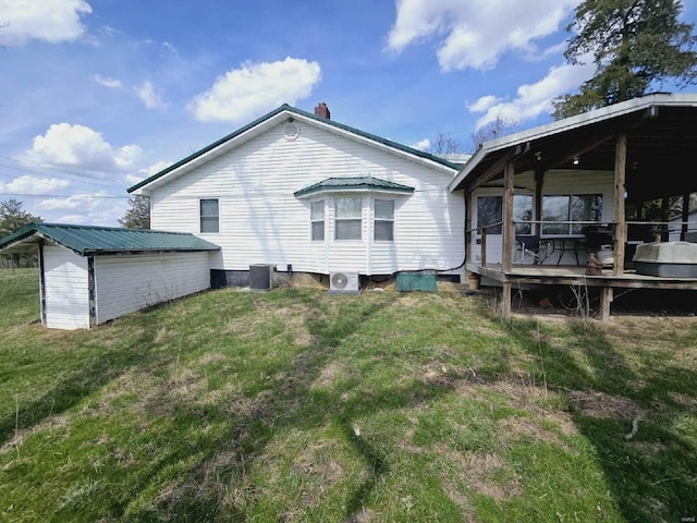 rear view of property featuring a deck, a yard, and central AC unit