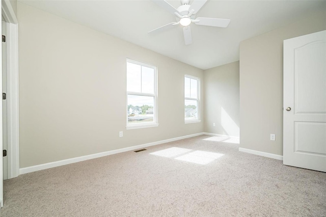 unfurnished room with light colored carpet and ceiling fan