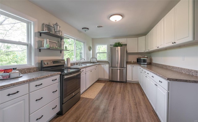 kitchen featuring appliances with stainless steel finishes, wood-type flooring, and white cabinetry