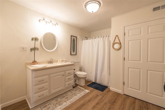 bathroom featuring wood-type flooring, vanity, toilet, and a shower with curtain