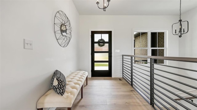 doorway to outside featuring a chandelier and wood-type flooring