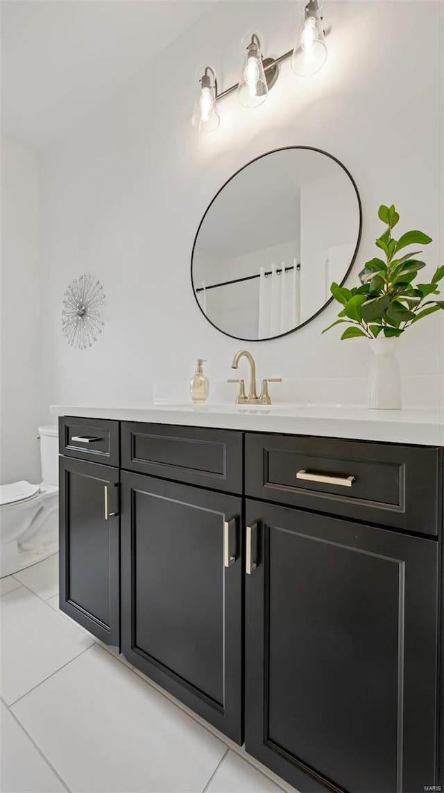 bathroom with tile patterned flooring, vanity, and toilet