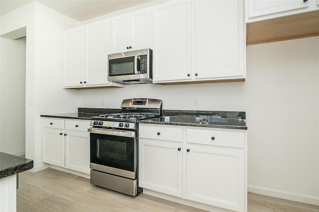 kitchen featuring white cabinets, light wood-type flooring, and stainless steel appliances