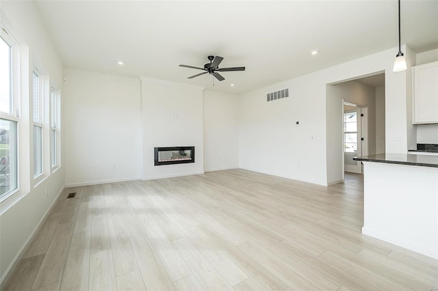 unfurnished living room featuring light hardwood / wood-style floors and ceiling fan