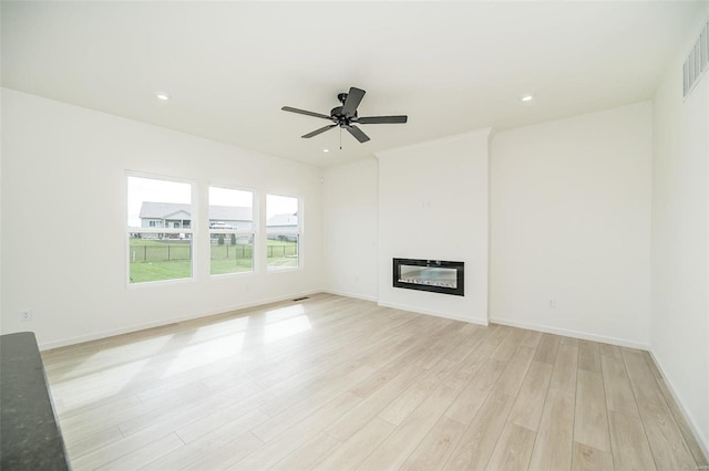 unfurnished living room featuring ceiling fan and light hardwood / wood-style flooring