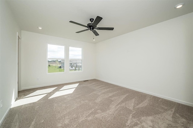 carpeted spare room featuring ceiling fan