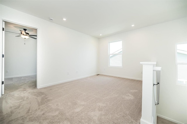 carpeted spare room featuring ceiling fan