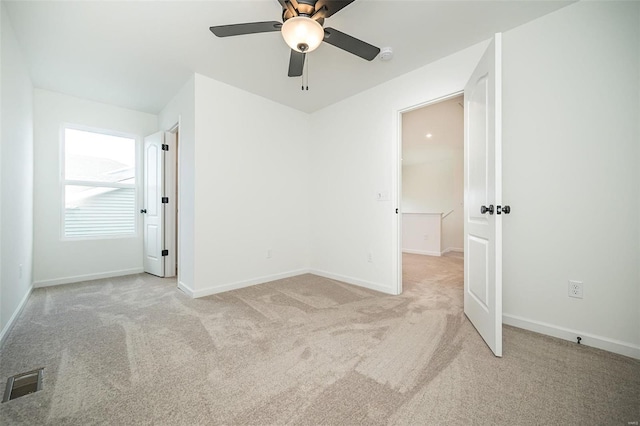 unfurnished bedroom featuring light colored carpet and ceiling fan