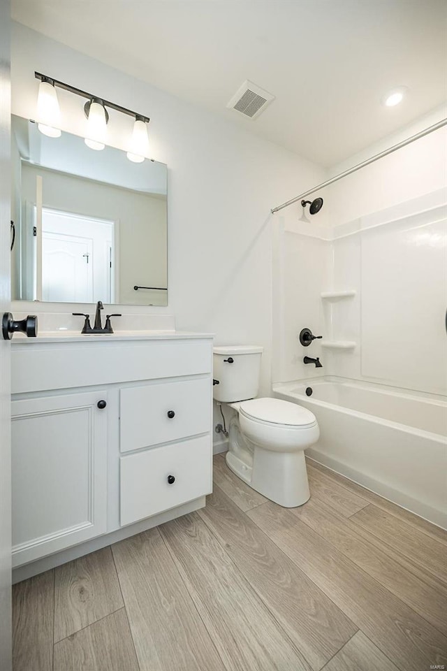 full bathroom featuring shower / bath combination, vanity, toilet, and wood-type flooring