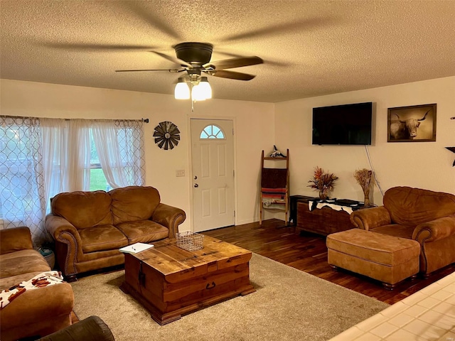 living room featuring a textured ceiling, wood finished floors, and a ceiling fan