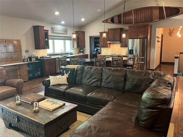 living room with vaulted ceiling, sink, and dark wood-type flooring