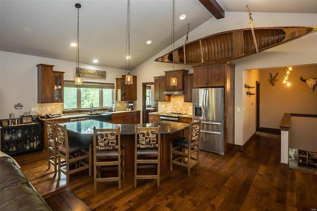 kitchen with a kitchen island, stainless steel refrigerator with ice dispenser, dark hardwood / wood-style flooring, and backsplash