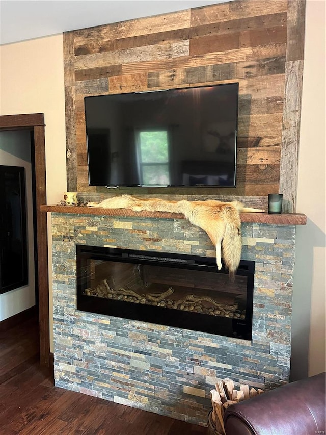 details featuring a stone fireplace and dark hardwood / wood-style floors