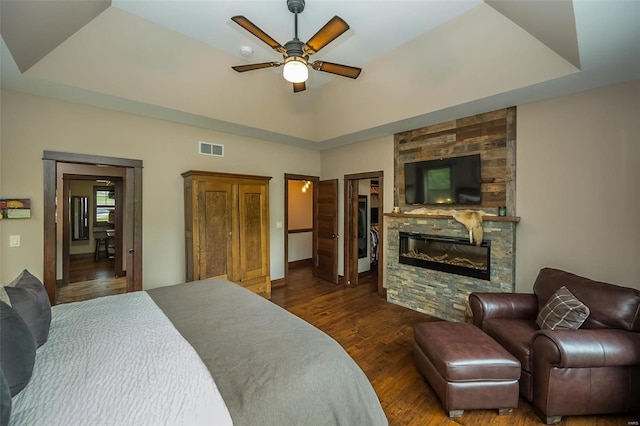 bedroom featuring dark hardwood / wood-style flooring, a spacious closet, ceiling fan, and a raised ceiling