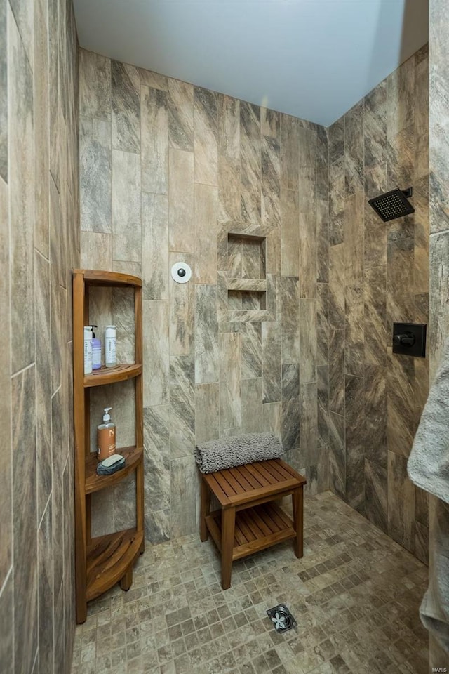 bathroom with tiled shower and tile walls