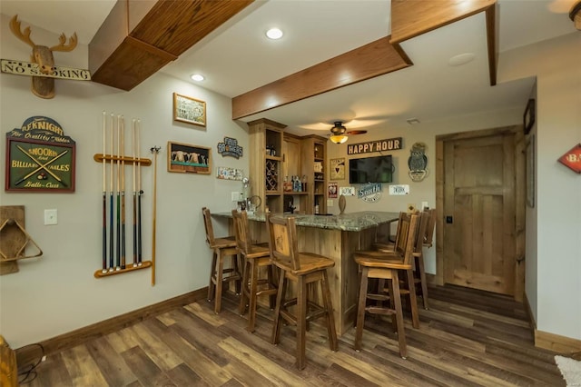 dining area with bar, dark hardwood / wood-style flooring, and ceiling fan