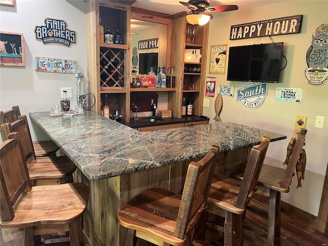 bar featuring ceiling fan and hardwood / wood-style flooring