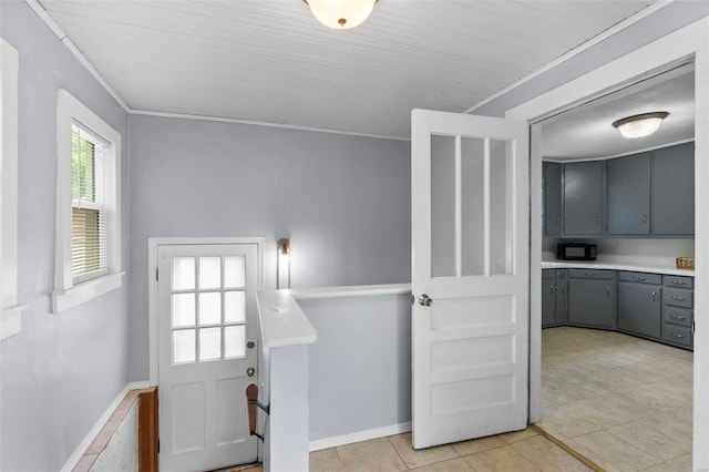 interior space with ornamental molding and light tile floors