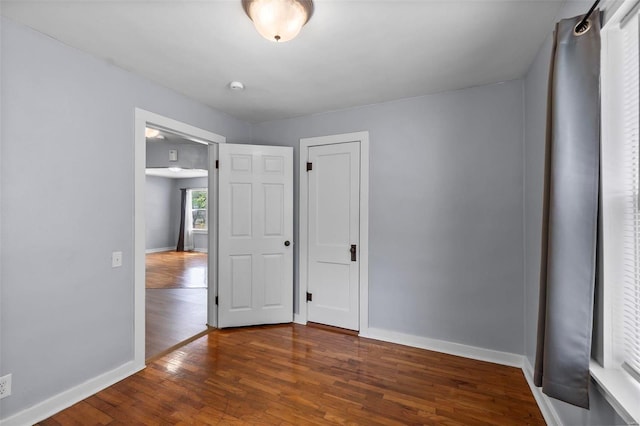 unfurnished room with dark hardwood / wood-style flooring