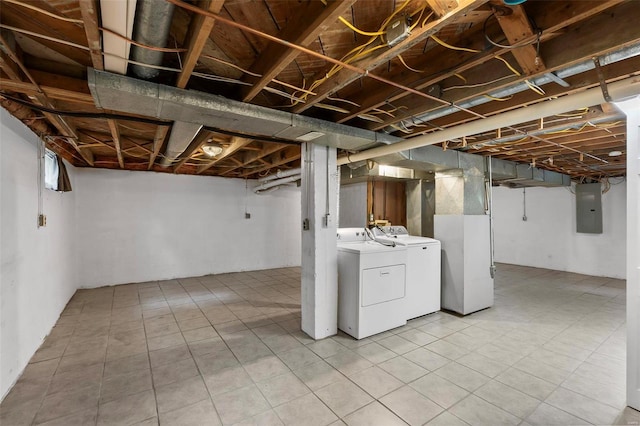 basement featuring light tile floors and washing machine and clothes dryer