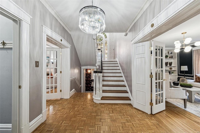 stairway featuring built in shelves, parquet floors, a chandelier, and ornamental molding