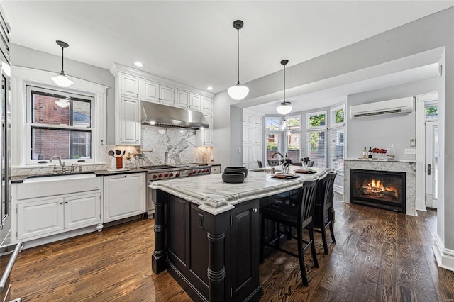 kitchen with tasteful backsplash, white cabinets, pendant lighting, and a kitchen island