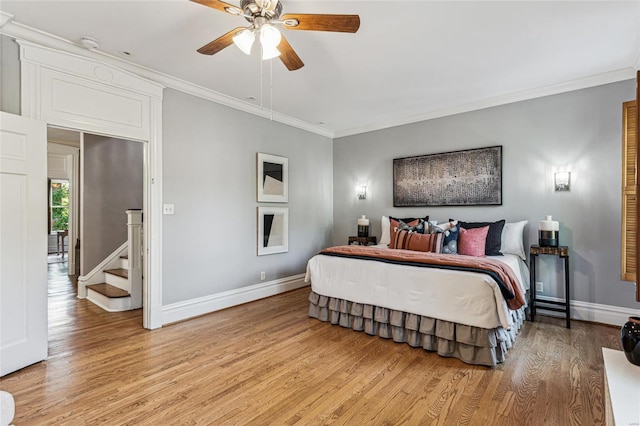 bedroom featuring ceiling fan, crown molding, and light hardwood / wood-style flooring