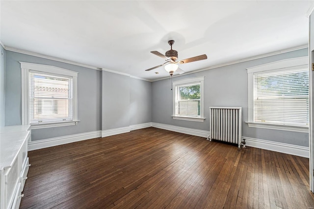 empty room with radiator, plenty of natural light, ornamental molding, and dark hardwood / wood-style floors