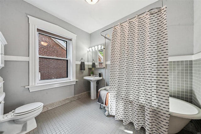 bathroom featuring tile patterned flooring, sink, tile walls, toilet, and a shower with shower curtain