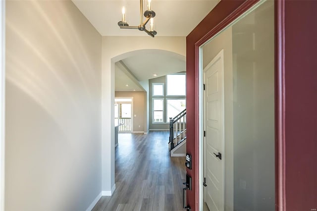 hallway with a notable chandelier and dark hardwood / wood-style floors