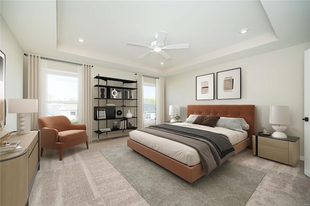 bedroom featuring a raised ceiling, multiple windows, and ceiling fan