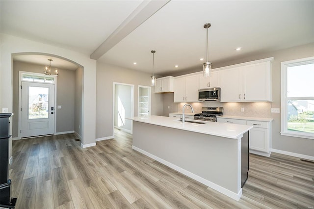 kitchen with hanging light fixtures, appliances with stainless steel finishes, a wealth of natural light, and sink