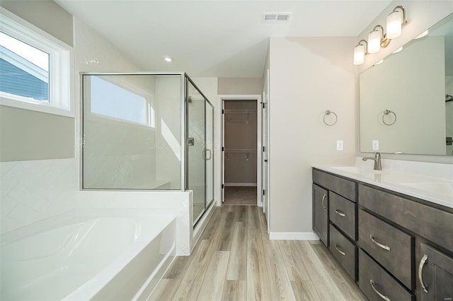 bathroom featuring wood-type flooring, vanity, and shower with separate bathtub