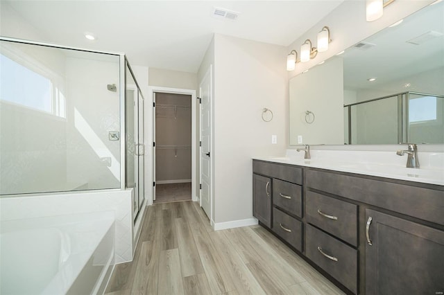 bathroom with hardwood / wood-style flooring, vanity, and independent shower and bath