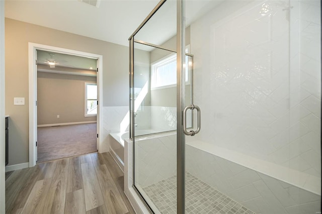 bathroom featuring plus walk in shower and hardwood / wood-style flooring