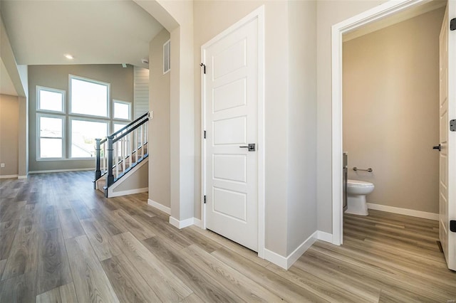 hall featuring light hardwood / wood-style floors and lofted ceiling