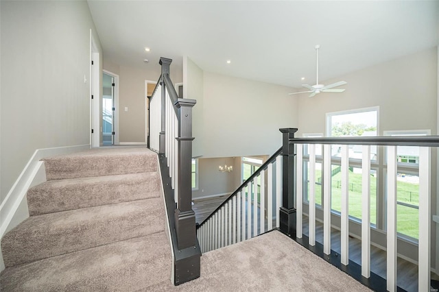 stairway with carpet flooring and ceiling fan