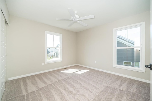 carpeted spare room featuring ceiling fan