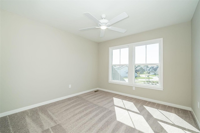 spare room with ceiling fan and light colored carpet