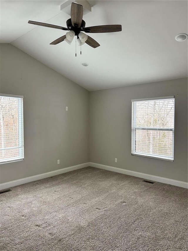 carpeted spare room featuring vaulted ceiling, a healthy amount of sunlight, and ceiling fan