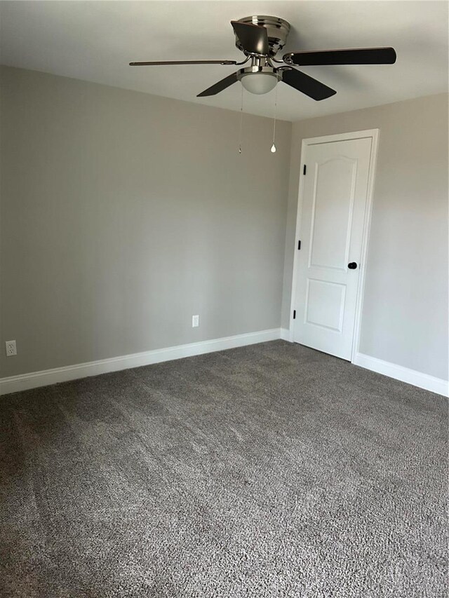 unfurnished room featuring ceiling fan and dark colored carpet