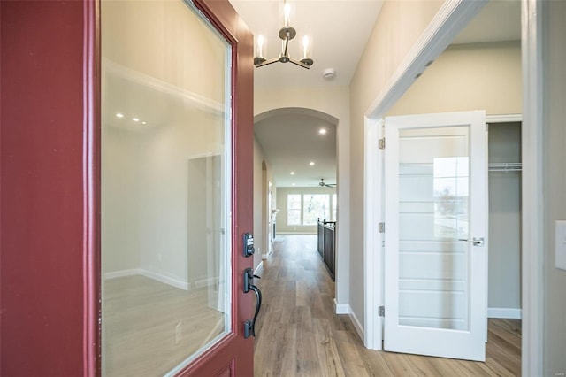 corridor featuring light hardwood / wood-style floors and a chandelier