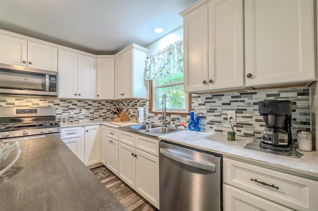 kitchen featuring sink, stainless steel appliances, tasteful backsplash, dark hardwood / wood-style floors, and white cabinets