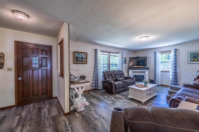 living room featuring a textured ceiling, dark hardwood / wood-style floors, and a healthy amount of sunlight