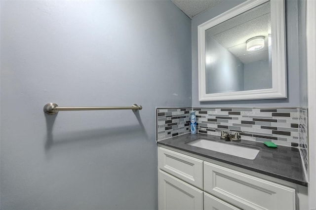 bathroom with vanity, a textured ceiling, and tasteful backsplash