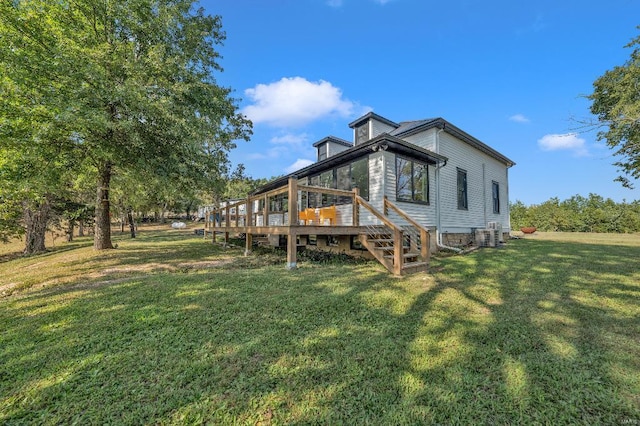 rear view of property featuring a wooden deck and a yard