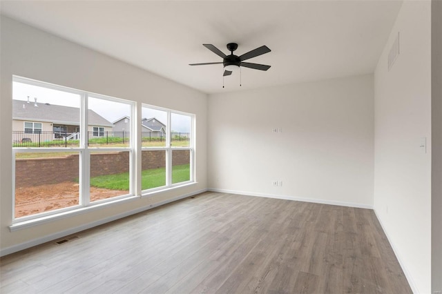 spare room with ceiling fan and light wood-type flooring